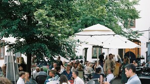 An outdoor dining area with tables and chairs, surrounded by trees and umbrellas. - NOFO Hotel, WorldHotels Crafted (Stockholm)