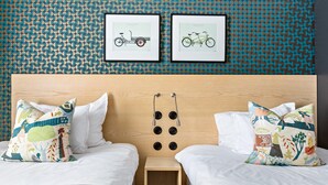 A hotel room with two beds, a wooden headboard, and a wall with a circular pattern. - NOFO Hotel, WorldHotels Crafted (Stockholm)
