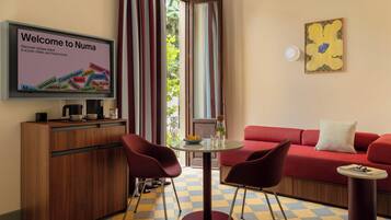 Ein modernes Wohnzimmer mit einem roten Sofa, einem Holzschrank, einem Fernseher und einem karierten Boden.