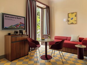 A modern living room with a red sofa, a wooden cabinet, a TV, and a checkered floor. - Numa Florence della Robbia (Florence)