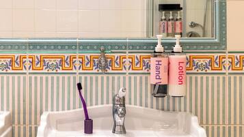 A bathroom sink with a toothbrush holder, a mirror, and toiletries.