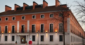 A large, multi-story building with a classic architectural style, featuring a symmetrical facade with evenly spaced windows and a central entrance. - NH Collection Palacio de Aranjuez (Aranjuez)
