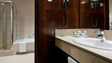 A modern bathroom with a glass shower enclosure, a large sink with a mirror, and a towel rack.