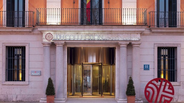 Entrada de un edificio con puerta giratoria, un letrero que dice 