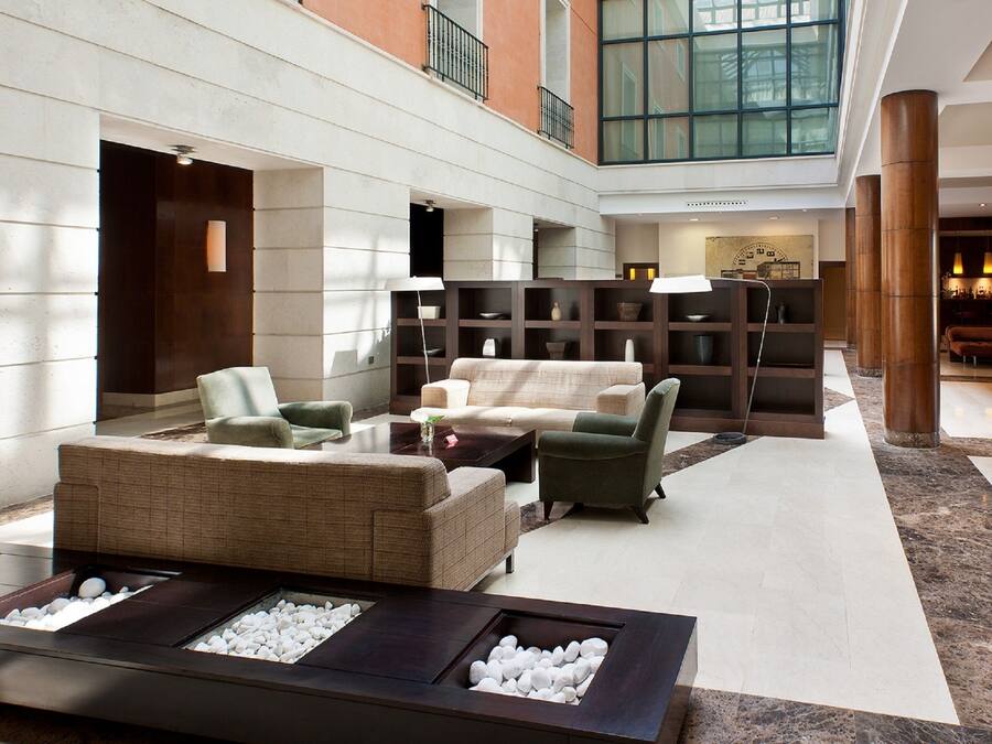 A spacious lobby with a seating area, a fireplace, and a large bookshelf.