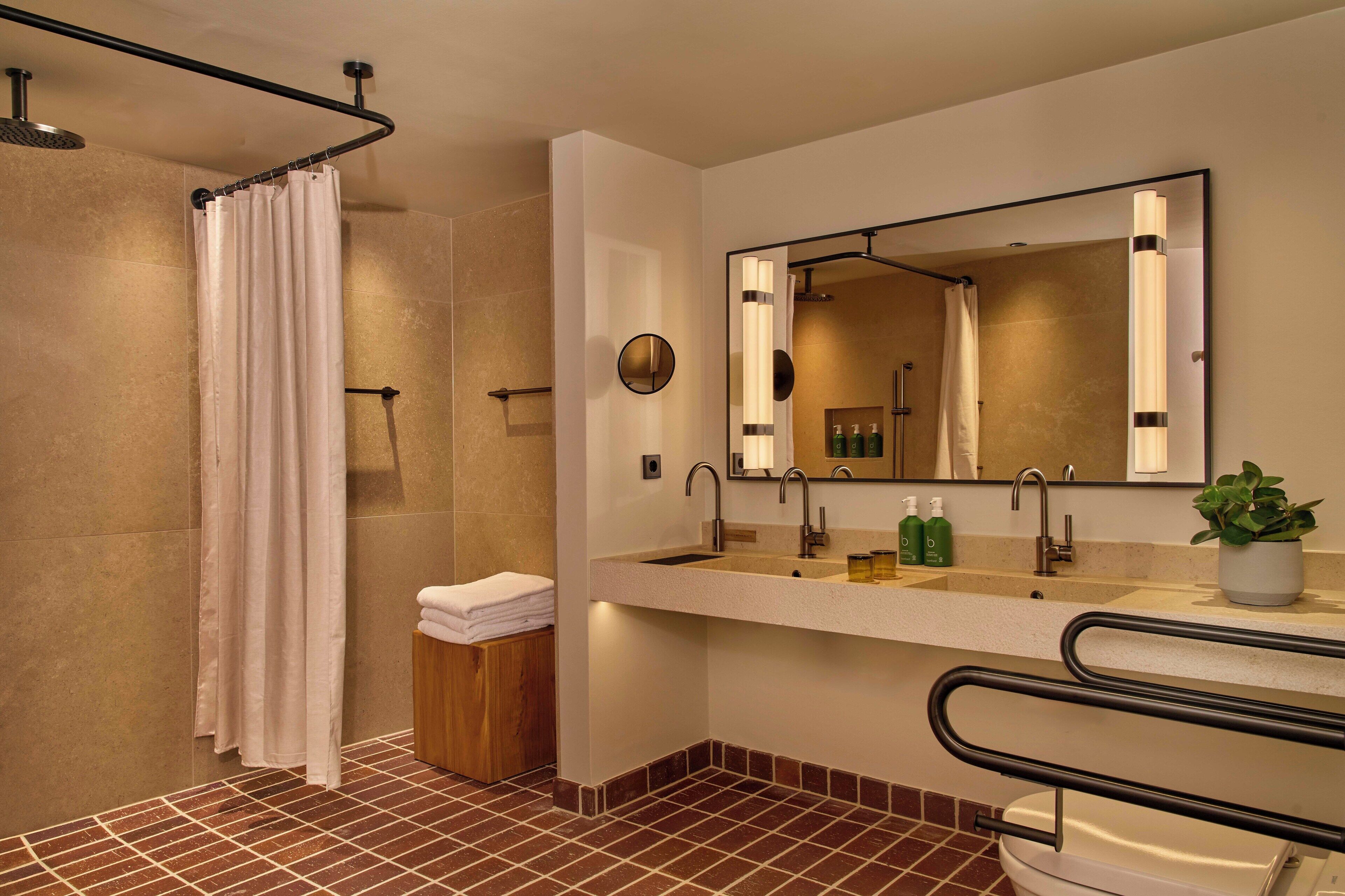 Ein modernes Badezimmer mit Dusche, Waschbecken mit Spiegel und Toilette.