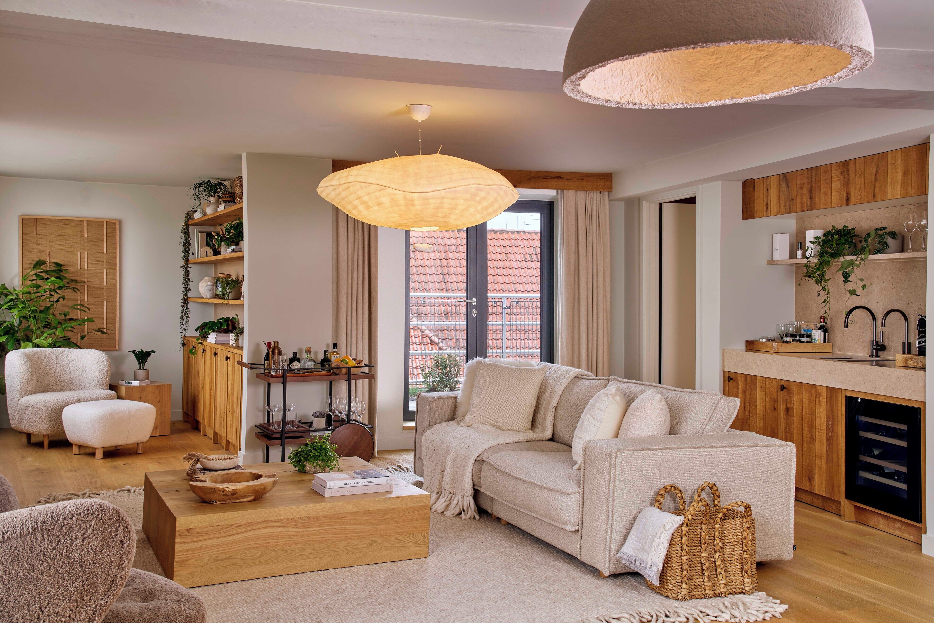 Ein modernes Wohnzimmer mit einer Couch, einem Couchtisch und einer Pendelleuchte.