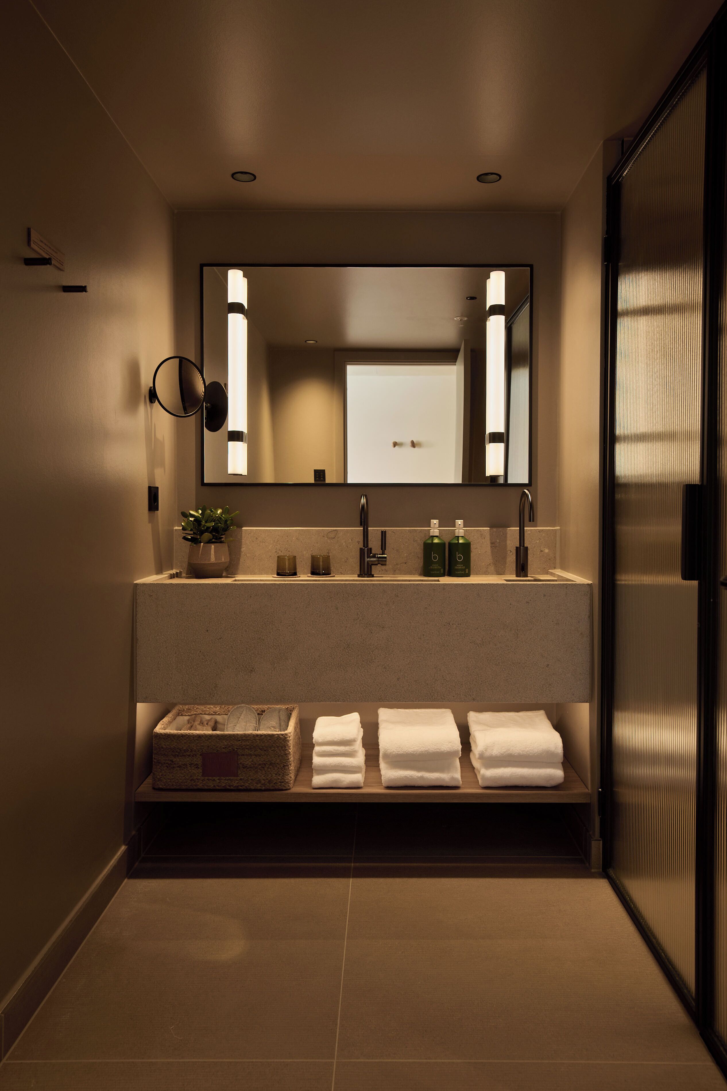 A modern bathroom with a double sink, a large mirror, and a towel rack.