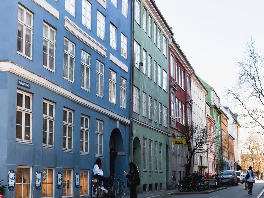 Una strada con edifici colorati, un manto stradale in pietra e una bicicletta.