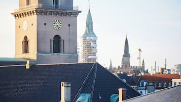 Un edificio histórico con una torre del reloj, ventanas en arco y un campanario destacado al fondo.