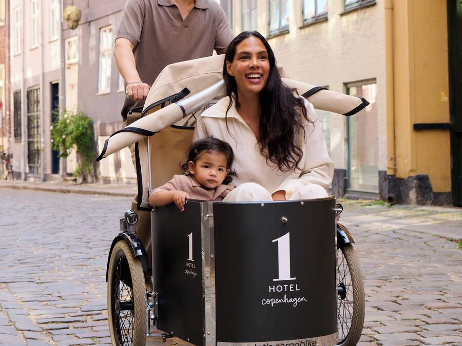 Una bicicleta de carga con una caja negra etiquetada 'HOTEL Copenhagen' y el número '1'.