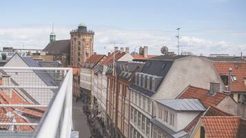 Vista de una calle con edificios históricos, una torre y un puente.