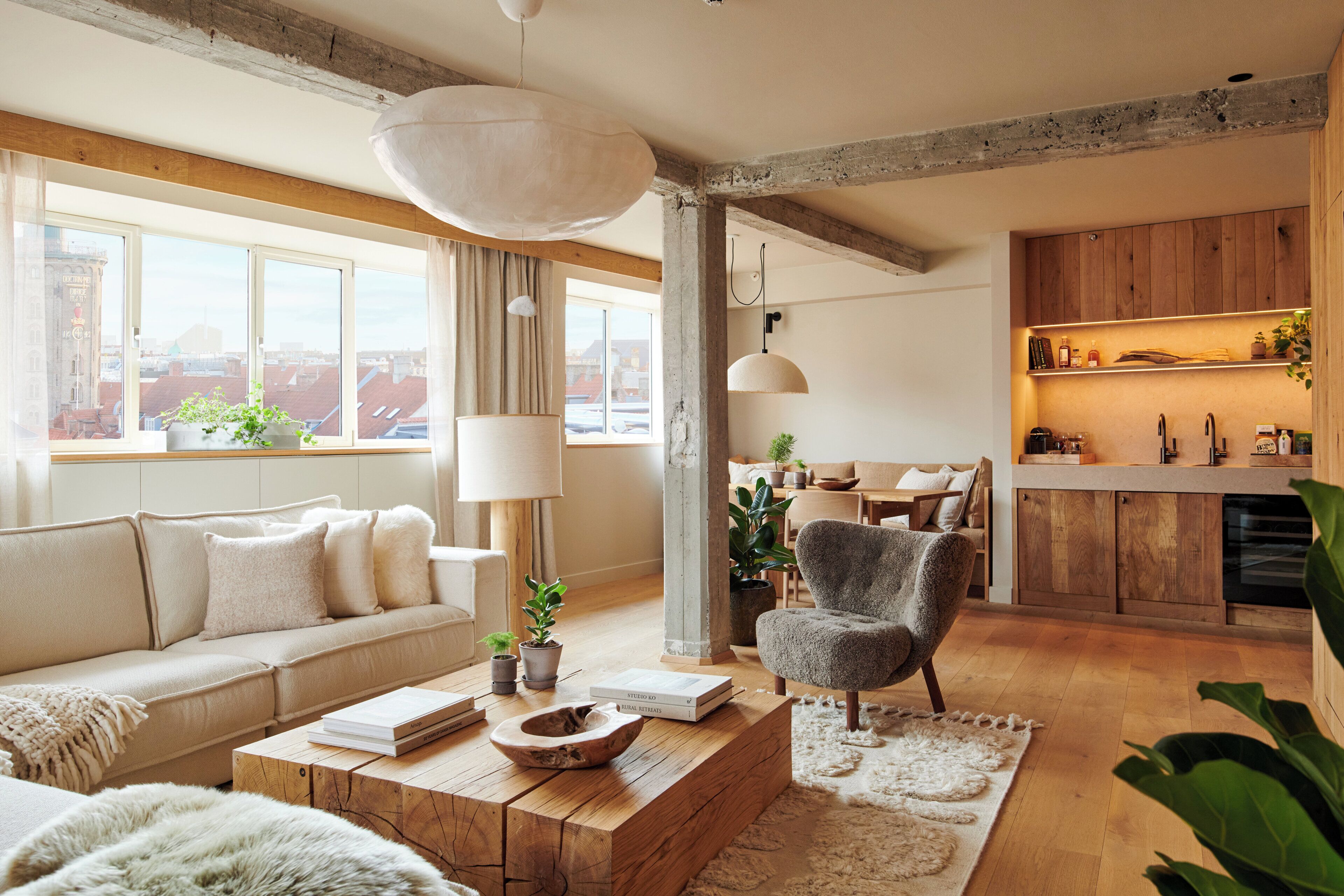 A modern living room with a sofa, coffee table, and a dining area with a chair and table.