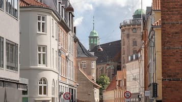 Eine Straße mit Gebäuden, einem Radfahrer und Fußgängern.