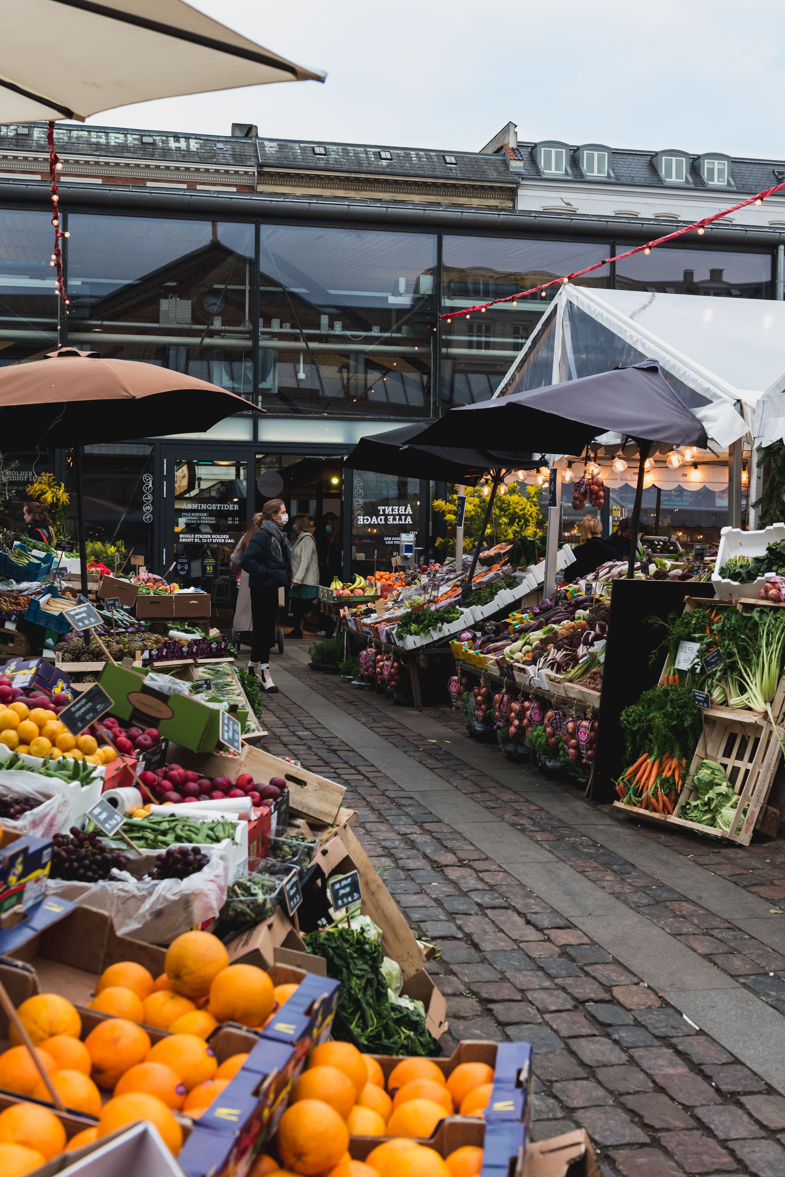 Un mercado al aire libre con varios puestos que venden frutas y verduras.