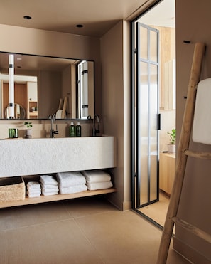 A modern bathroom with a large mirror, a bathtub, and a shower area.