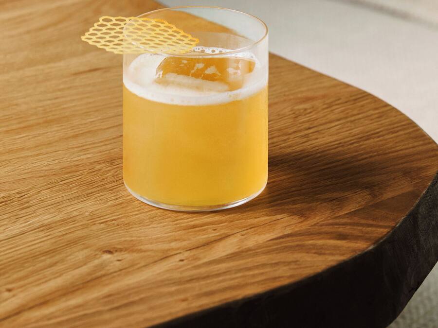 A glass of beer on a wooden table.