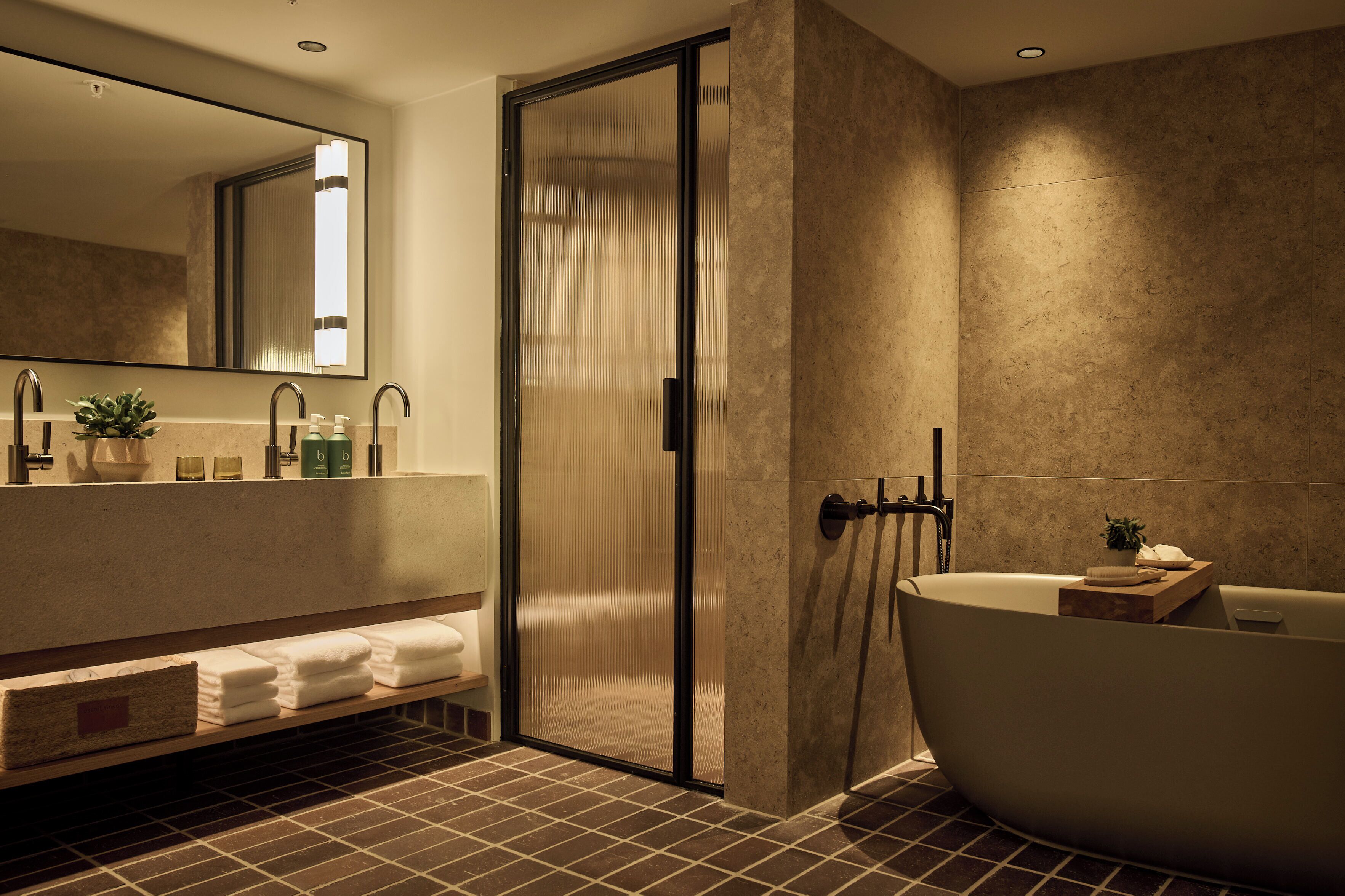 Ein modernes Badezimmer mit freistehender Badewanne, einer Duschkabine aus Glas und einem großen Spiegel.
