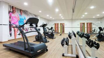 Een sportschool met loopbanden, elliptische trainers en gewichtbanken.