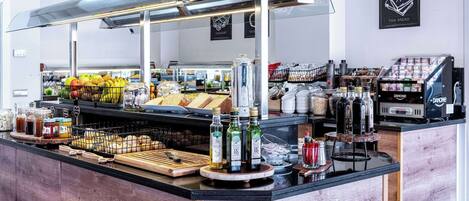 Un café moderno con mostrador de madera, diversas opciones de comida y una máquina de café.