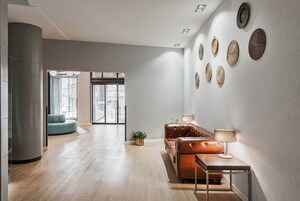 Una sala de estar moderna con un sofá, una mesa de centro y decoración en la pared.