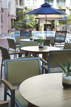 A poolside area with tables and chairs, umbrellas, and potted plants. - Fraser Place Robertson Walk, Singapore (Singapore)