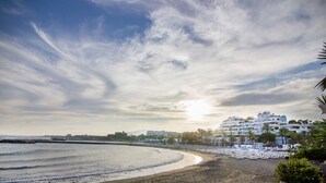A beach with a row of white buildings, a clear sky, and a calm sea. - Hotel Boutique B51 Puerto Banús (Marbella)