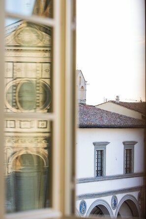 A building facade with arched windows and a tiled roof. - The Place Firenze (Florence)
