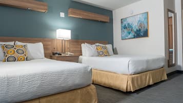 A hotel room with two beds, a nightstand, a lamp, and a painting on the wall.