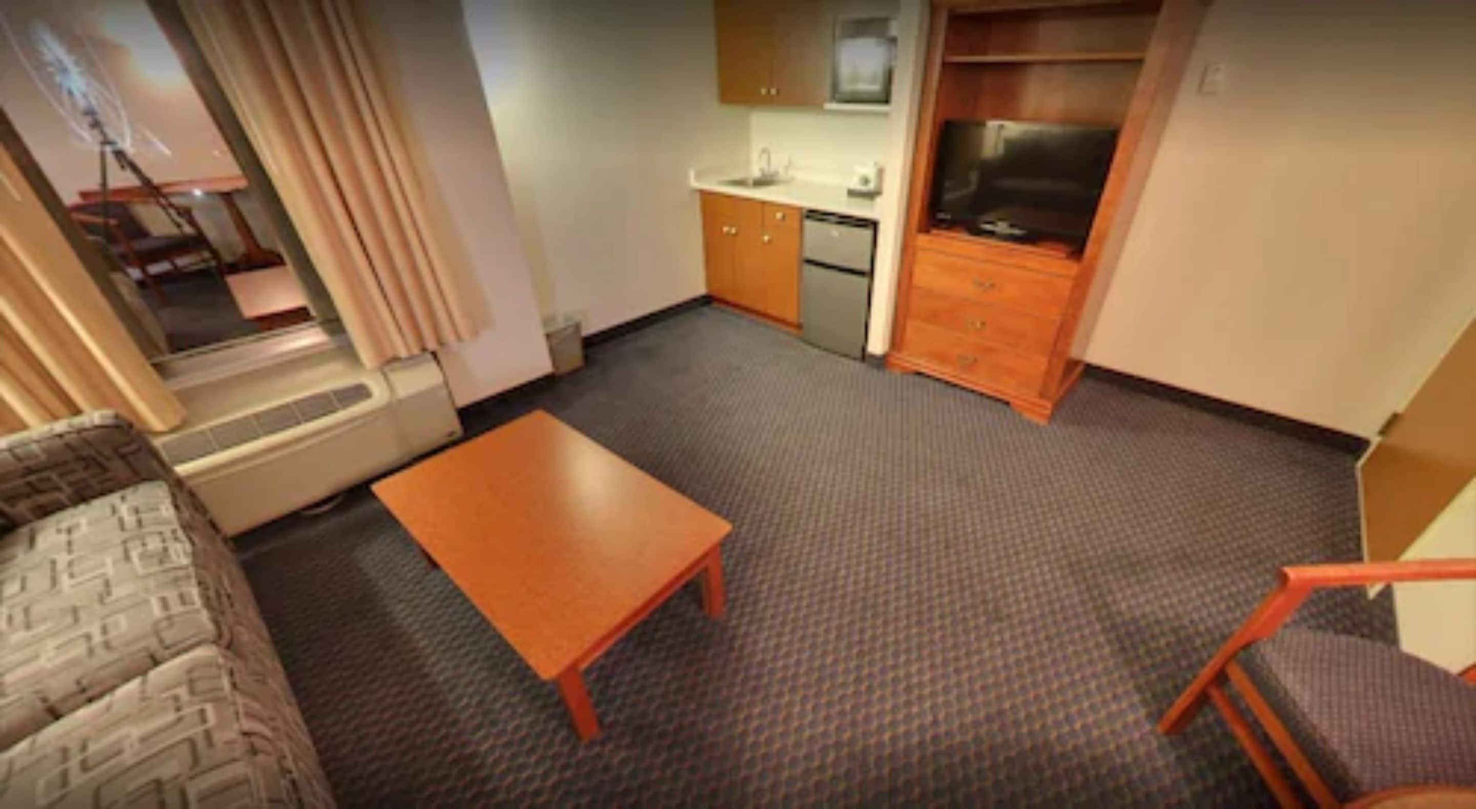 A compact living space with a kitchenette, a small dining table, and a sofa.