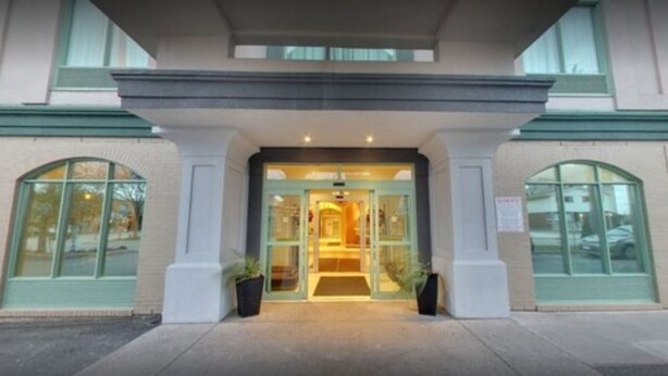 A hotel entrance with a glass door, a covered walkway, and a small entrance area with a mat. - Days Inn & Suites by Wyndham Niagara Falls Centre St. By the Falls (Niagara Falls)