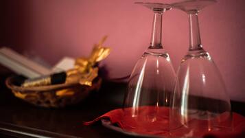 Two clear wine glasses on a red cloth with a basket in the background.