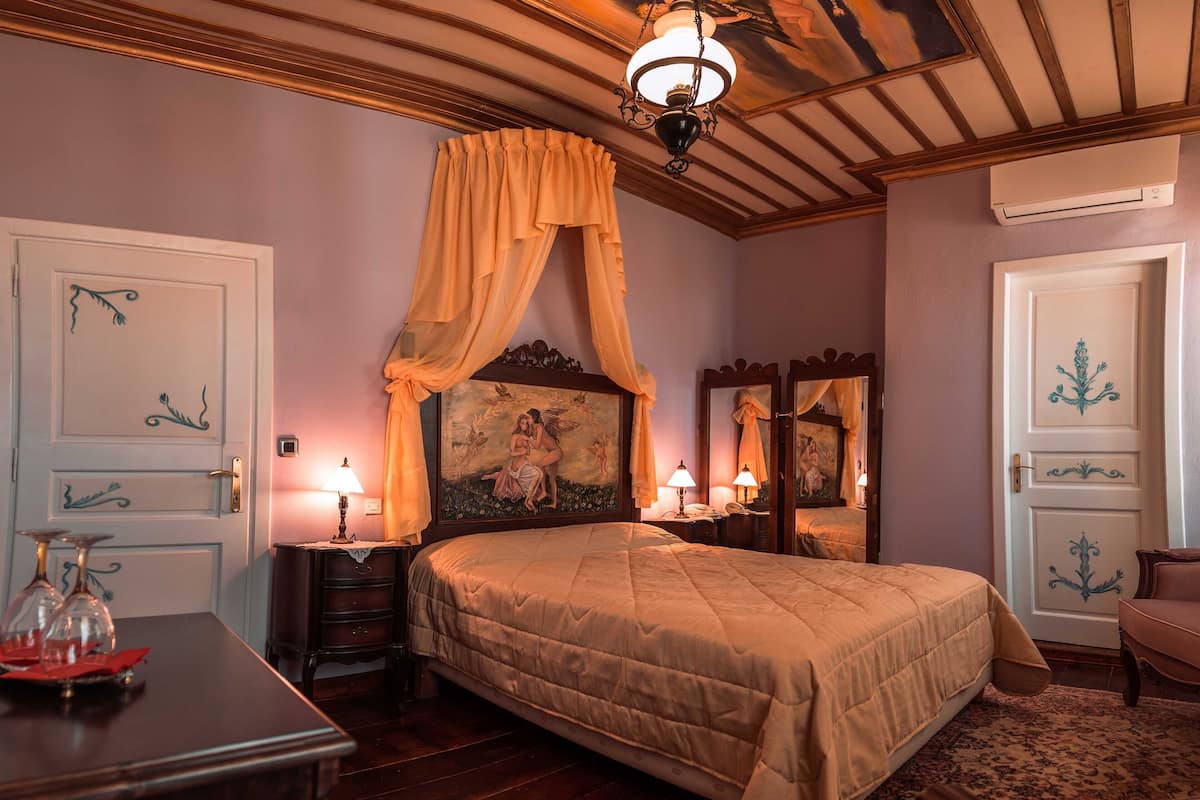 Un dormitorio con una cama grande, una mesita de noche, un aparador y un espejo.