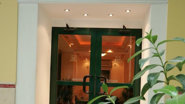A hotel entrance with a green door, a red roof, and a tiled floor. - Alma Hotel (Athens)