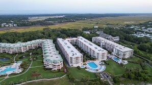 A large hotel complex with multiple buildings, a central swimming pool, and surrounding green spaces. - Hodnett Cooper's Beach Club (St. Simons Island)