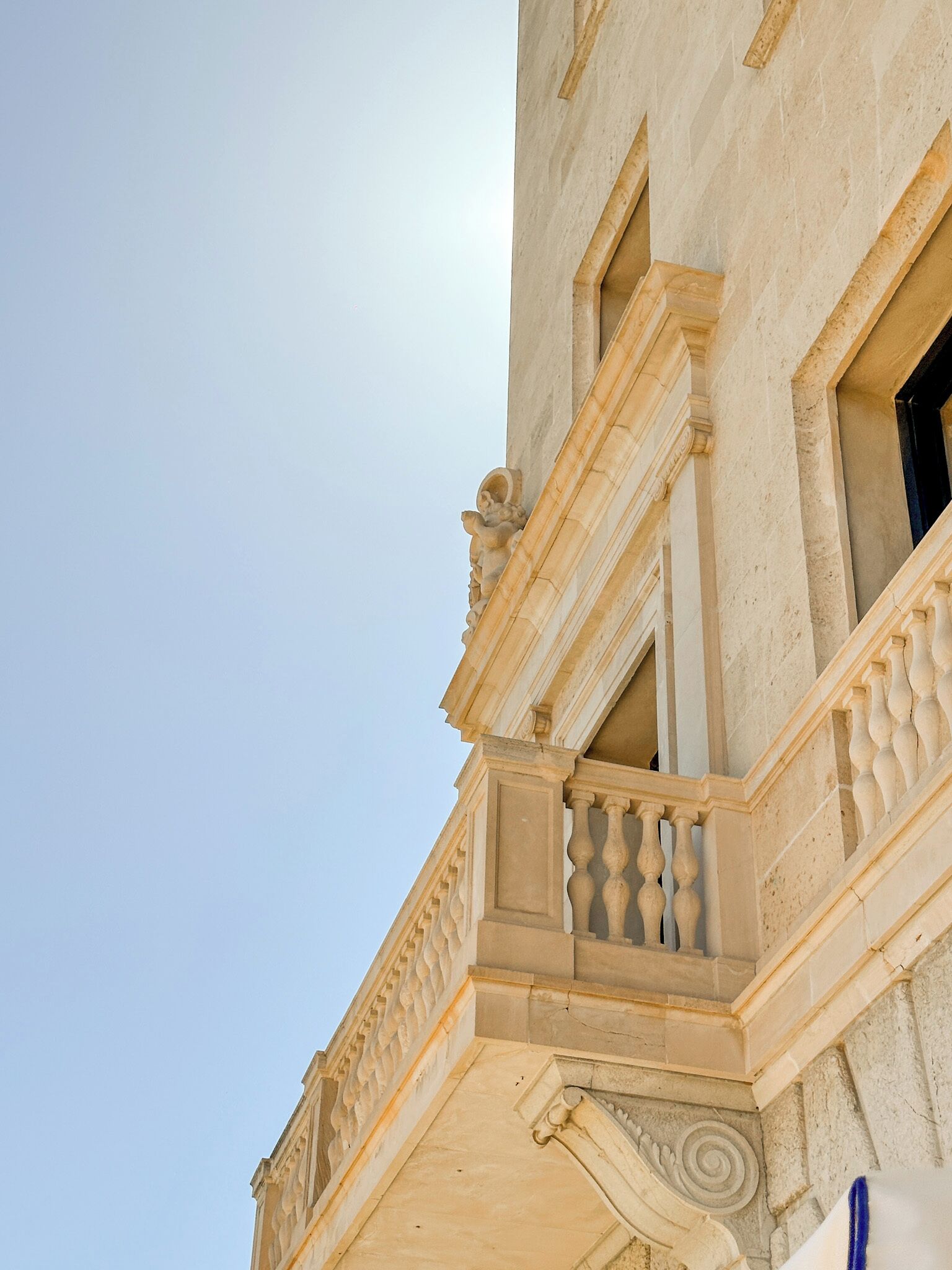 A building with a classical architectural style, featuring ornate balconies and detailed stonework.