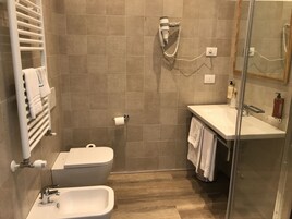 Un baño moderno con inodoro, bidé y lavamanos.