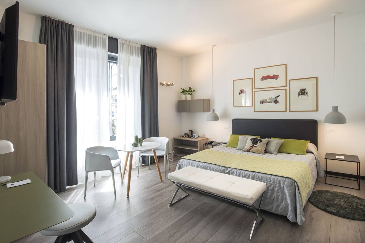 A modern bedroom with a bed, bedside tables, a desk, and a chair.