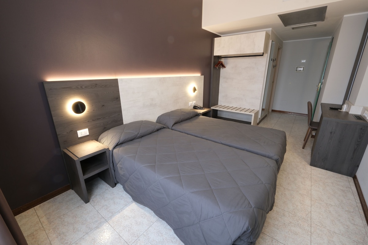 A modern bedroom with a large bed, bedside tables, and a built-in wardrobe.