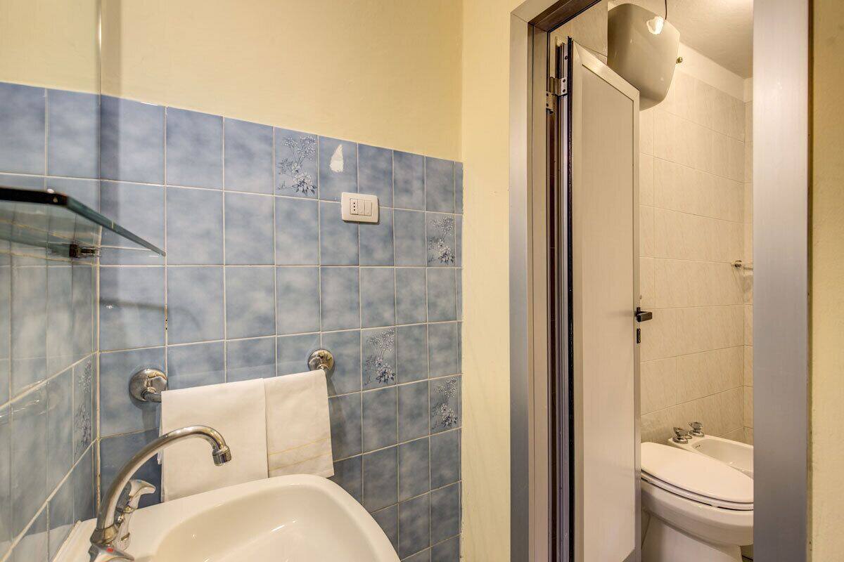 A bathroom with a sink, mirror, and a shower area.