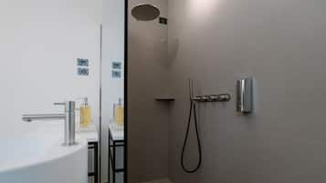 Un baño moderno con ducha, lavamanos e inodoro.