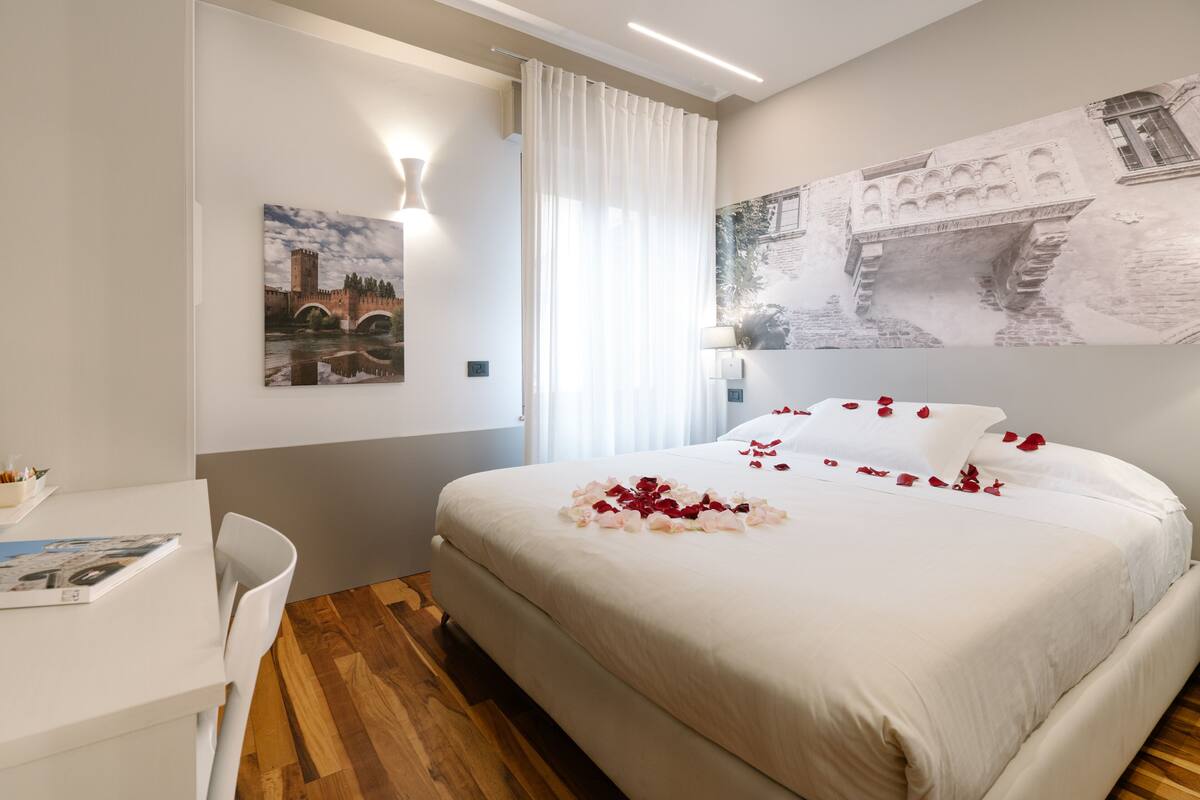 A hotel room with a bed, a desk, and a chair.