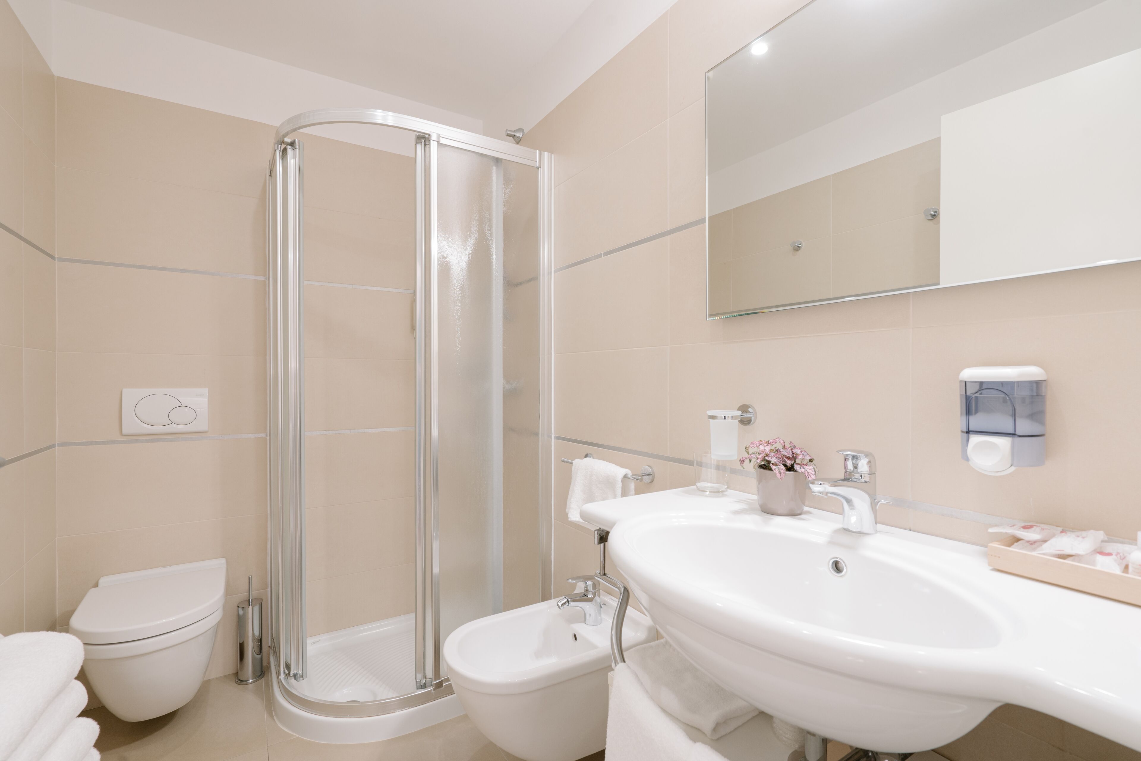 A modern bathroom with a glass-enclosed shower, a white sink, and a toilet.