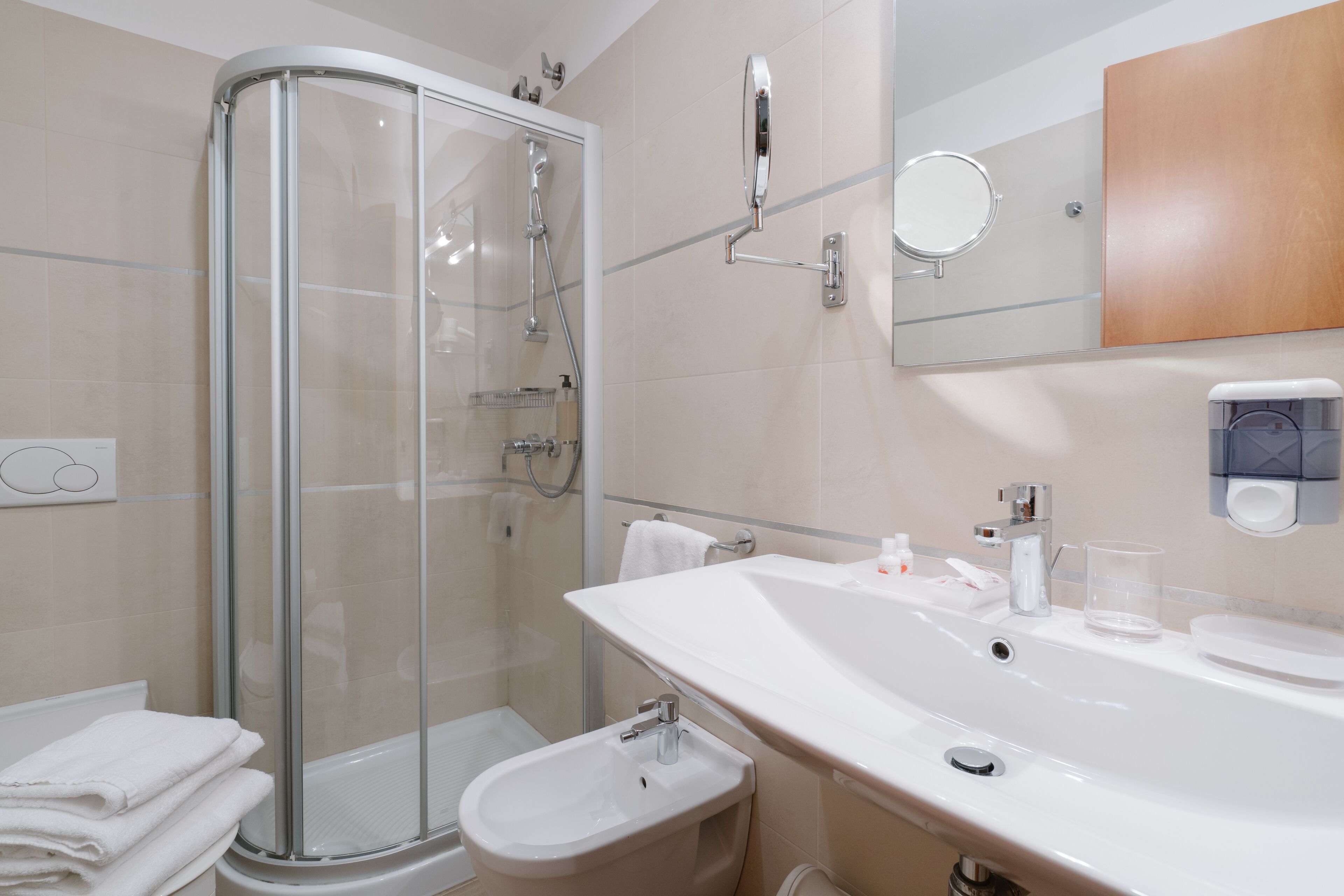 A modern bathroom with a glass-enclosed shower, a large sink, and a mirror.