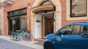 Un coche azul aparcado frente a un edificio con un letrero que dice 'Hotel Giuffretta e Romeo'.