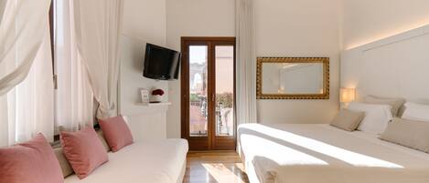 A hotel room with a bed, a TV, a mirror, and a view of the outside.