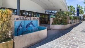 The entrance of Hotel Du Mare with a tiled pool area and a covered walkway. - Due Mari (Rimini)