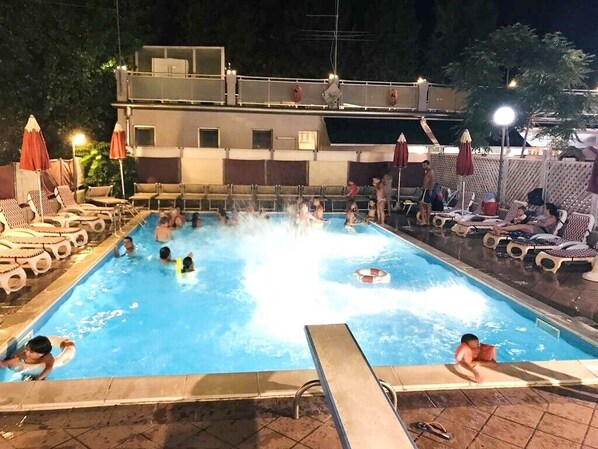 Una piscina al aire libre de temporada, sombrillas