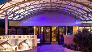 The entrance of Hotel Due Mari with a covered walkway and a decorative fountain. - Due Mari (Rimini)