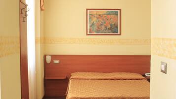 Habitación de hotel con cama, un cuadro en la pared y cabecero de madera.
